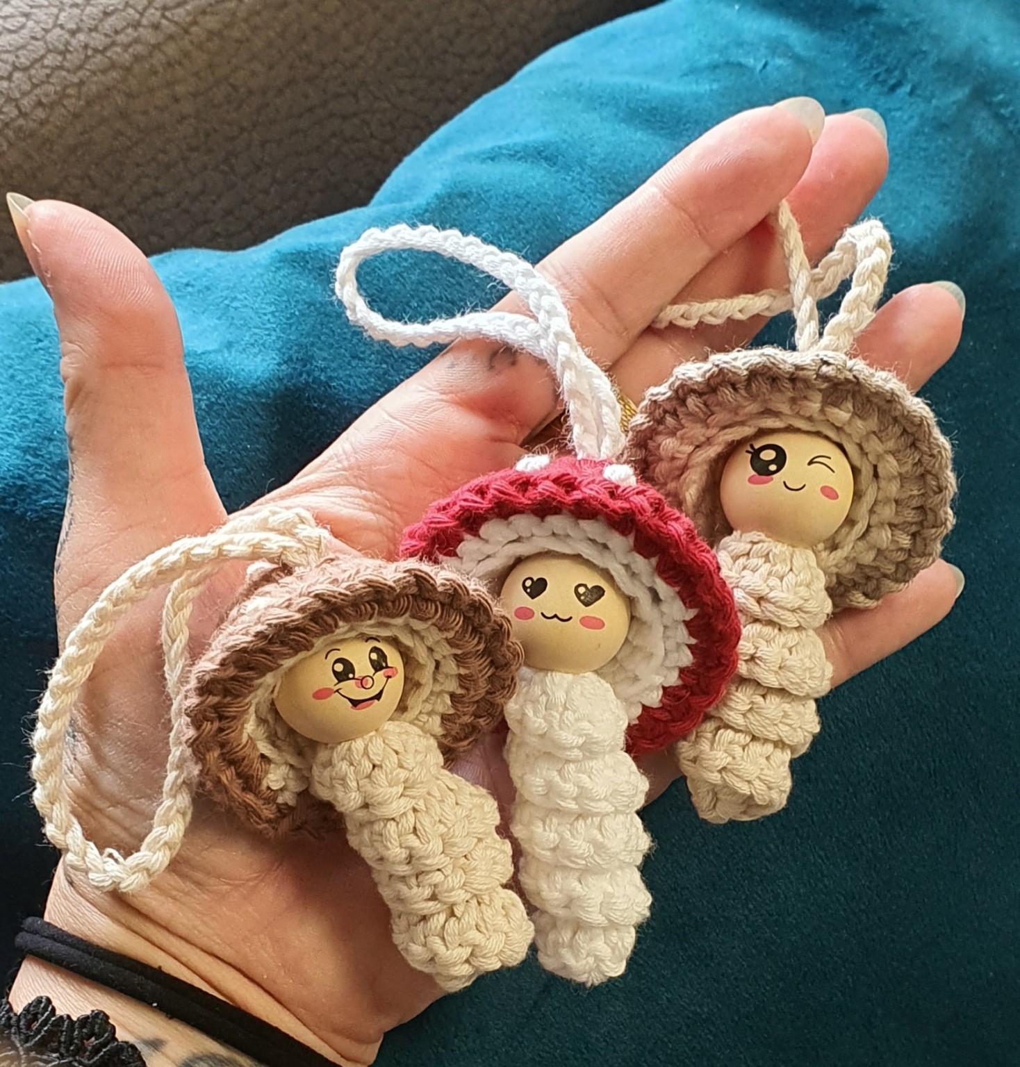 Drei kleine gehäkelte Pilzanhänger auf Morlas Hand